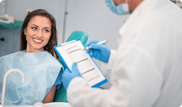 Dentist consults smiling patient in clinic.