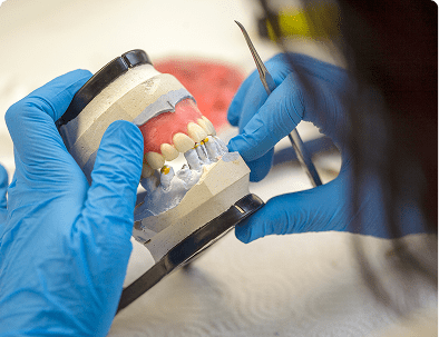 Dental technician working on a dental model.